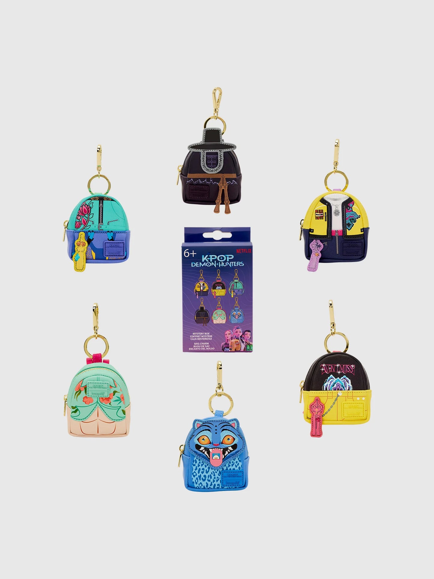 A K-Pop Demon Hunters mini backpack charm clipped onto a full-sized bag, showing the scale and gold hardware